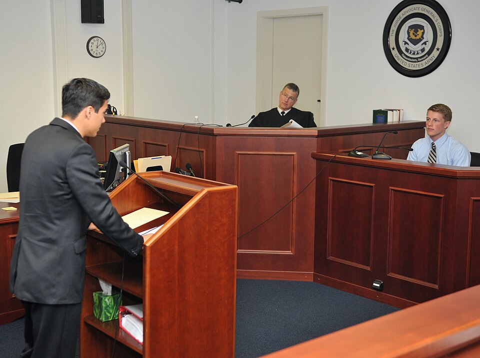 Justin Hebert, left, a senior at Kaiserslautern High School and lead prosecutor, questions Caleb Cha