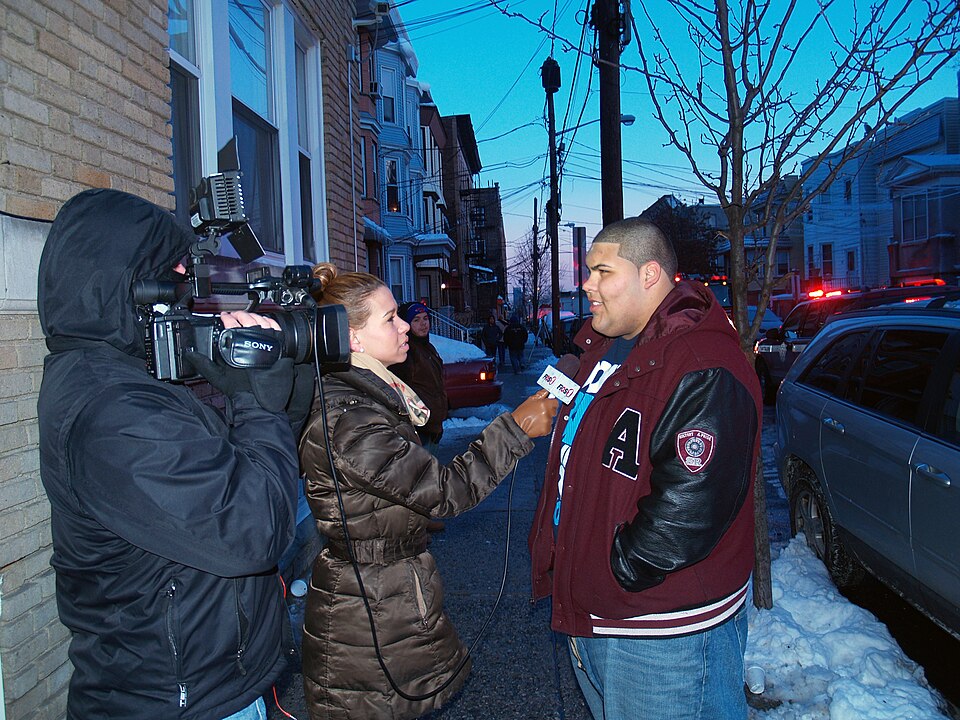 FiOS1 news reporter Raven Santana interviewing local citizen Adam Mejias at the scene of a six-alarm