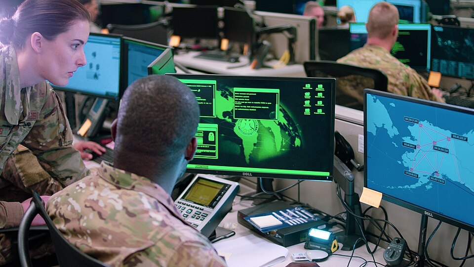 Capt. Sarah Miller and Tech. Sgt. Carrol Brewster, discuss options in response to a staged cyber-att