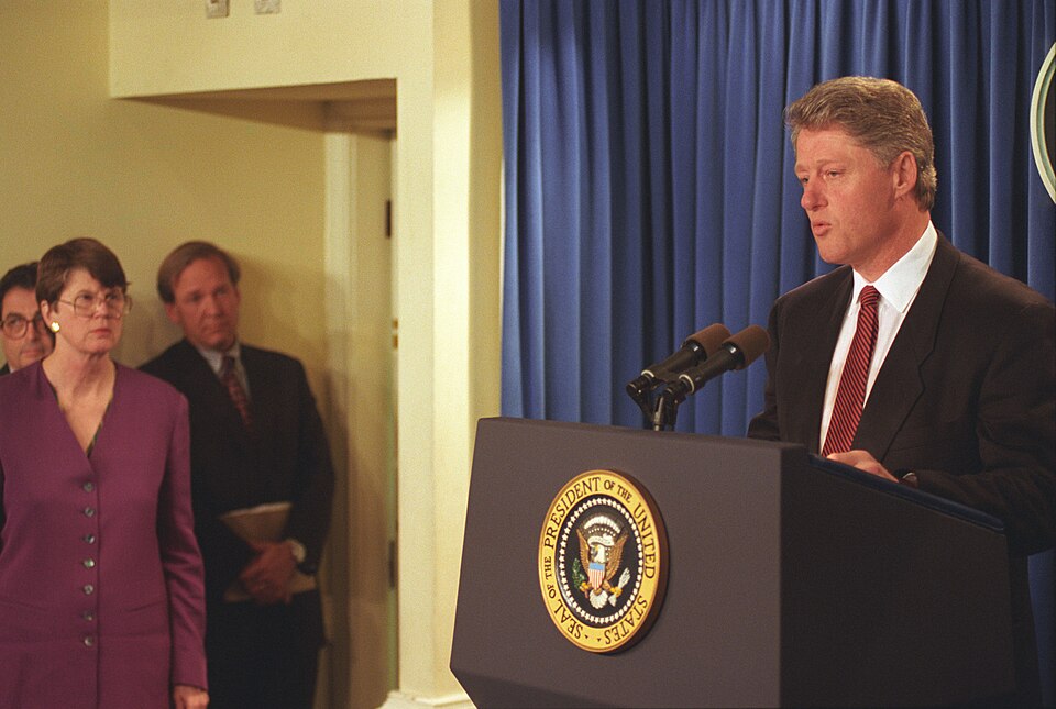 President Bill Clinton at the podium in the White House Press Briefing Room delivers a statement about the bombing in Oklahoma City, Oklahoma. U.S. Attorney General Janet Reno shown just off-stage gave a statement and addressed questions from reporters regarding the explosion at the Alfred P. Murrah