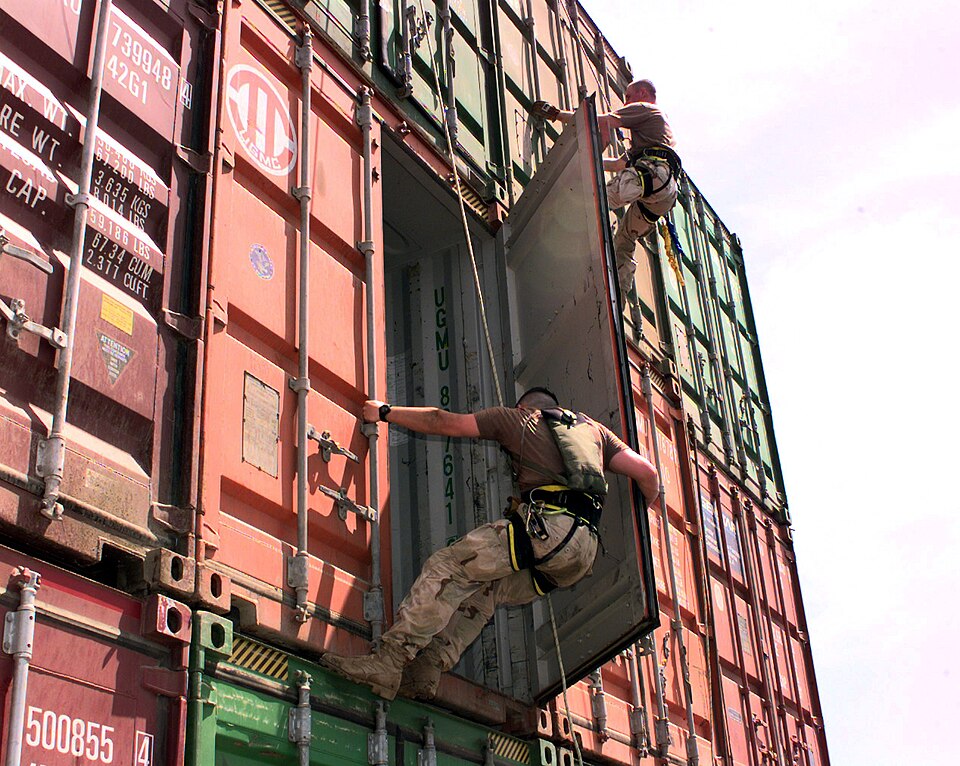 Boarding team members from the USS Lake Champlain (CG 57) rappel down cargo containers stacked on th
