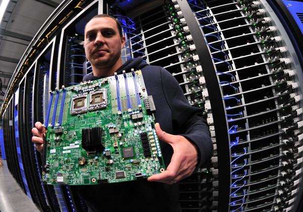 Facebook engineer Joshua Crass holds up a server board he and his team installed at the new data cen
